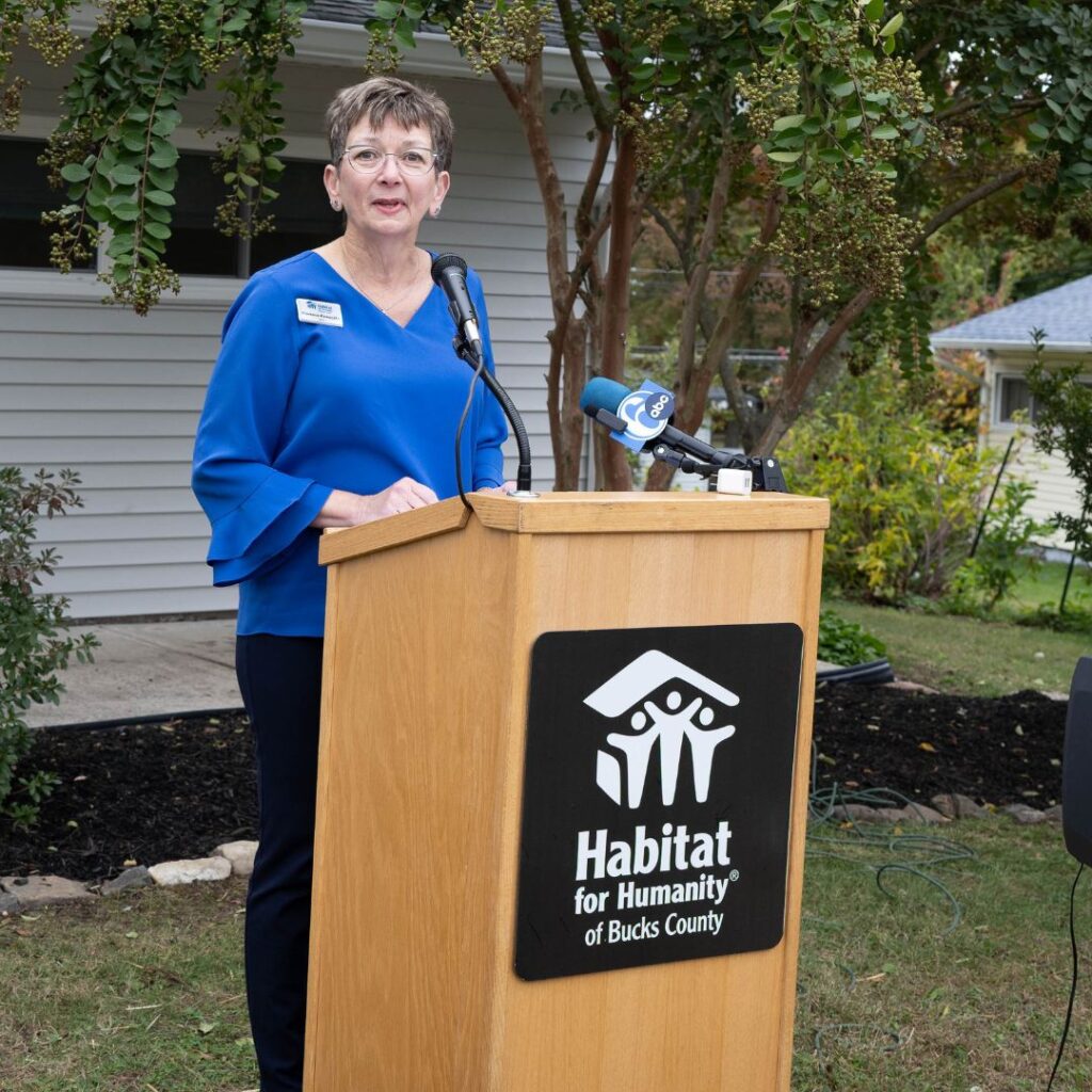 person in blue shirt speaking at podium