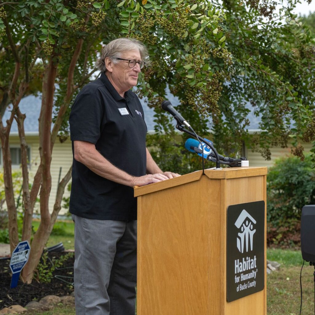 Person in black shirt speaking at podium