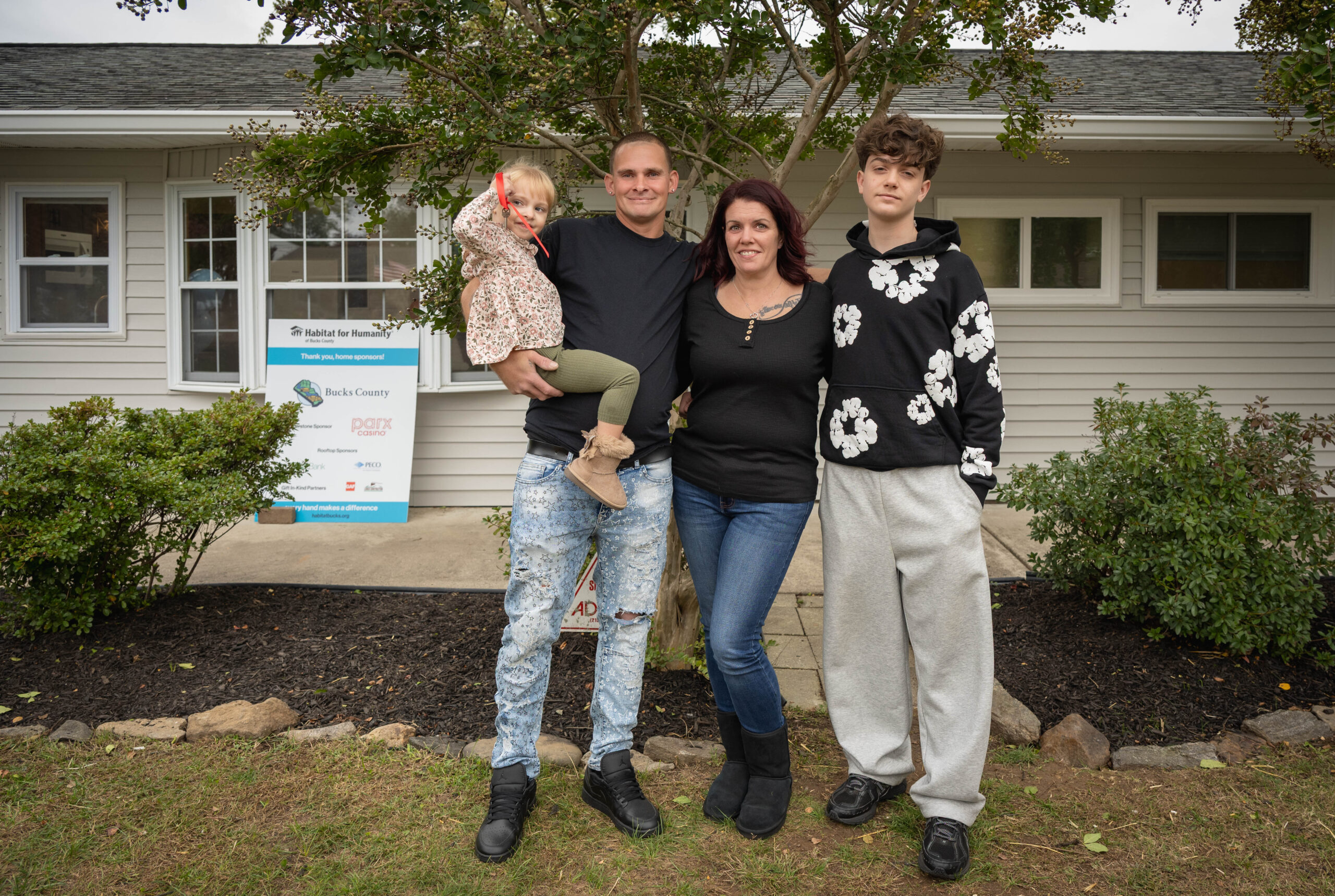 family in front of house